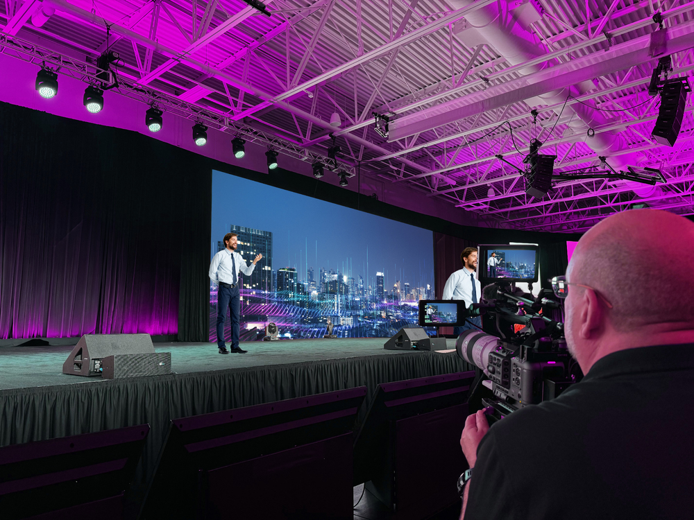 An executive speaking on stage at a corporate event An executive speaking on stage at a corporate event